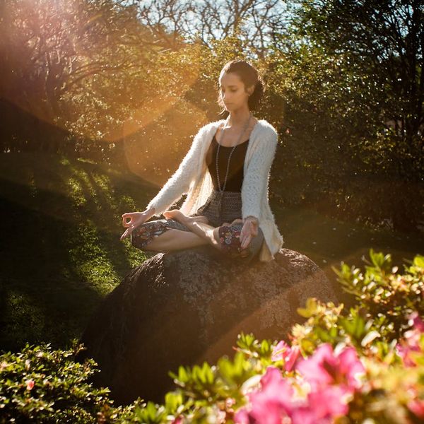 Person meditating in a calm natural environment, representing mental peace.